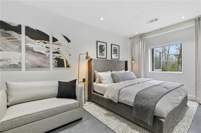 a bedroom with a bed couch and window