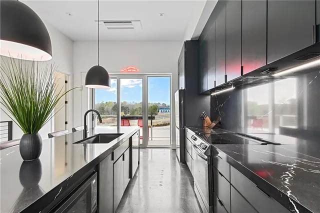 a kitchen with stainless steel appliances a sink a counter space a stove and a sink