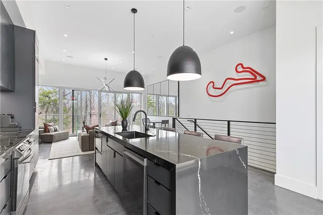 a kitchen with stainless steel appliances granite countertop a sink a stove and a wooden floor