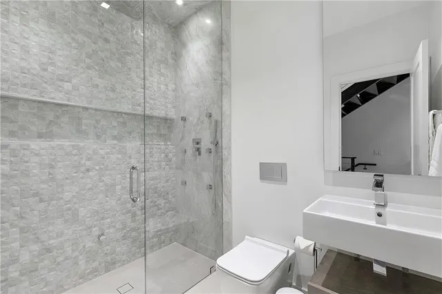 a bathroom with a sink toilet a mirror and shower