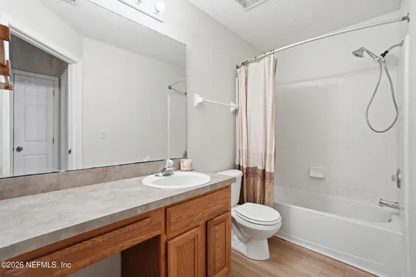 a bathroom with a granite countertop sink toilet a shower and a mirror