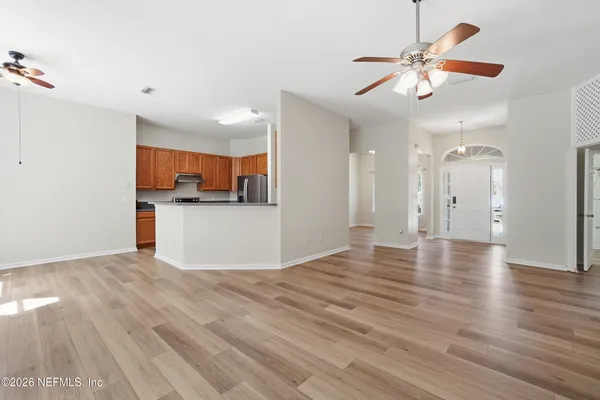 a kitchen with stainless steel appliances granite countertop a refrigerator a sink dishwasher a stove with wooden cabinets and floor