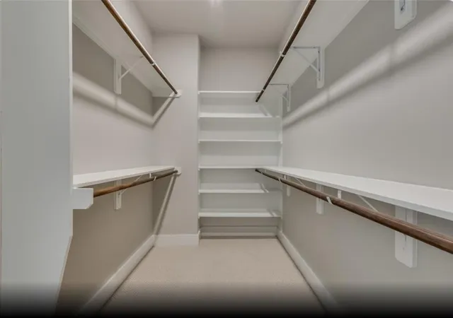 a view of walk in closet with empty racks