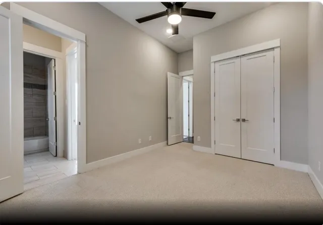 an empty room with fan and windows