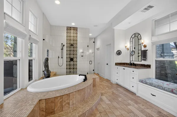 a spacious bathroom with a granite countertop sink mirror and bathtub