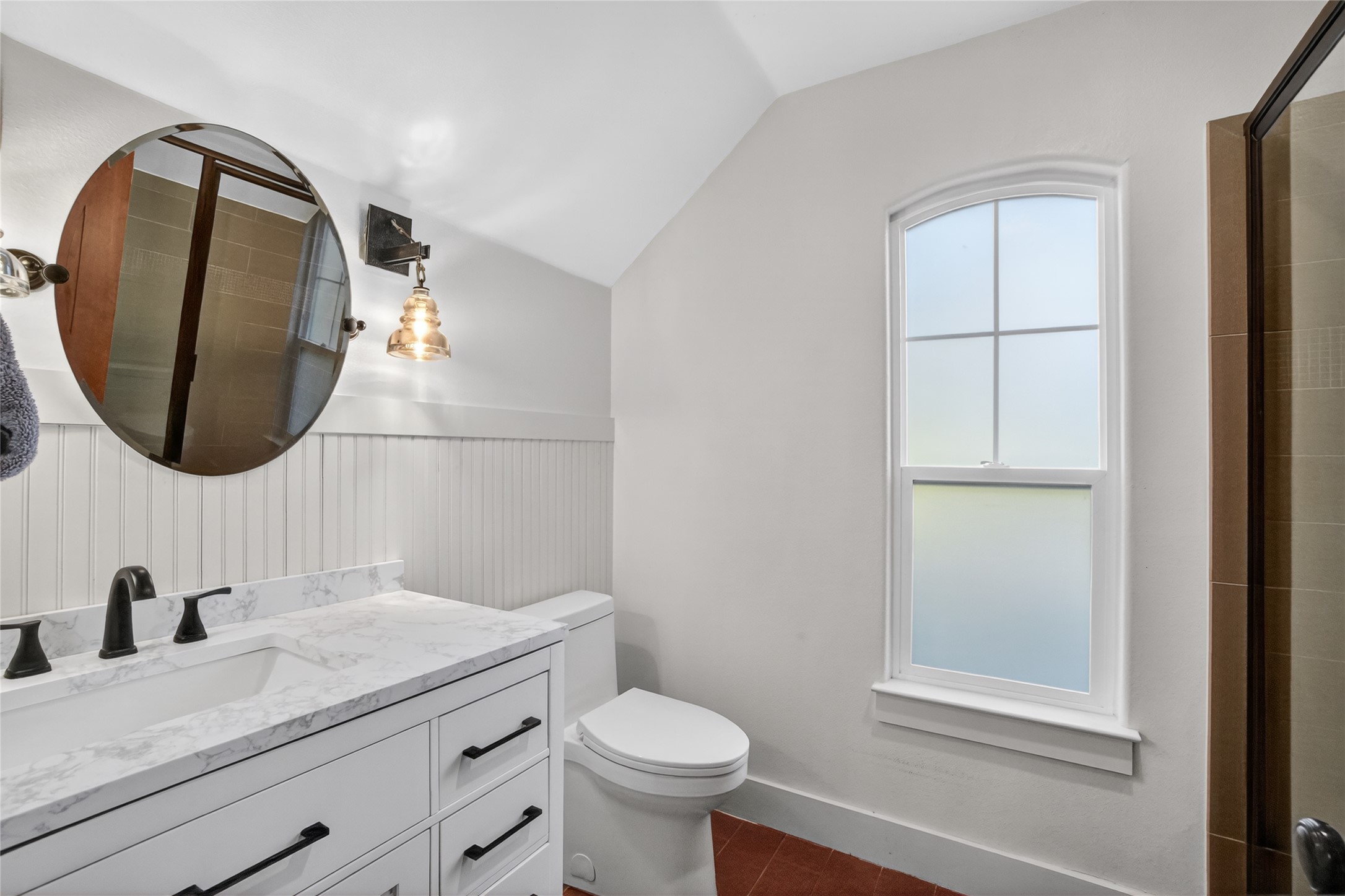 3627 Stoneridge Road, Unit 1 Austin, TX 78746 - Photo 22 of 39 Bathroom featuring vanity, a wainscoted wall, vaulted ceiling, and dark tile patterned flooring