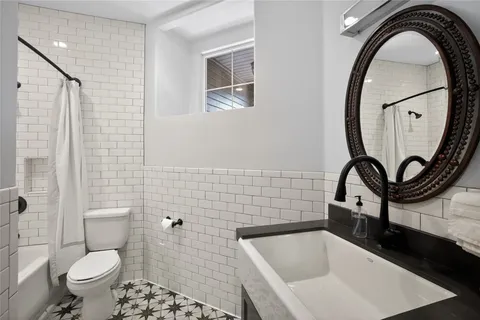 a bathroom with a granite countertop sink a toilet and a mirror