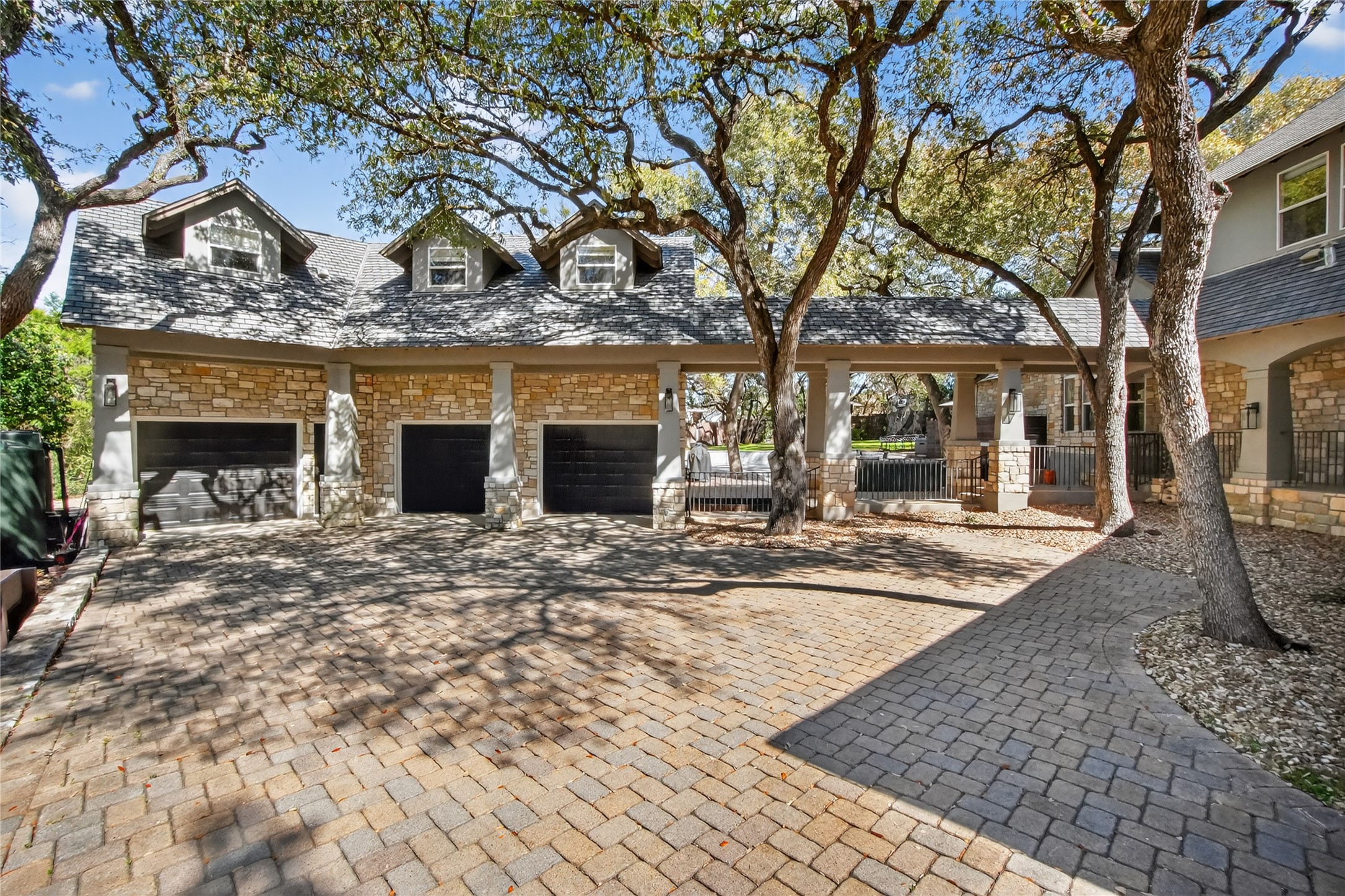 3627 Stoneridge Road, Unit 1 Austin, TX 78746 - Photo 28 of 39 View of front of property with stone siding, decorative driveway, and a garage