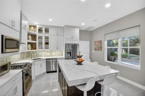 a view of a kitchen with a sink dishwasher refrigerator stove and a kitchen view