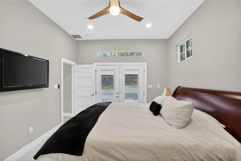 a bedroom with a large bed and a flat tv screen