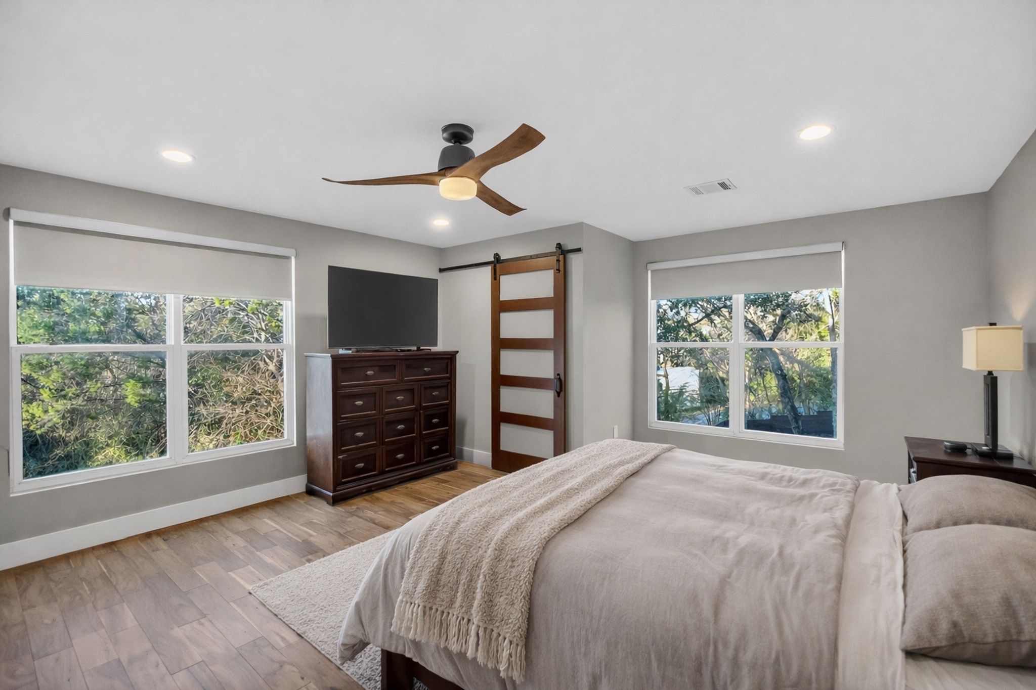 3627 Stoneridge Road, Unit 1 Austin, TX 78746 - Photo 39 of 39 Bedroom with light wood finished floors, a barn door, ceiling fan, multiple windows, and recessed lighting