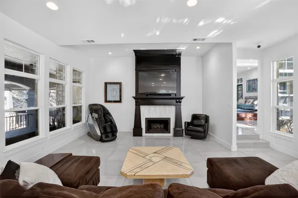 a living room with furniture a fireplace and a flat screen tv