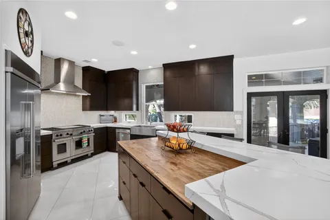 a large kitchen with cabinets in it and stainless steel appliances