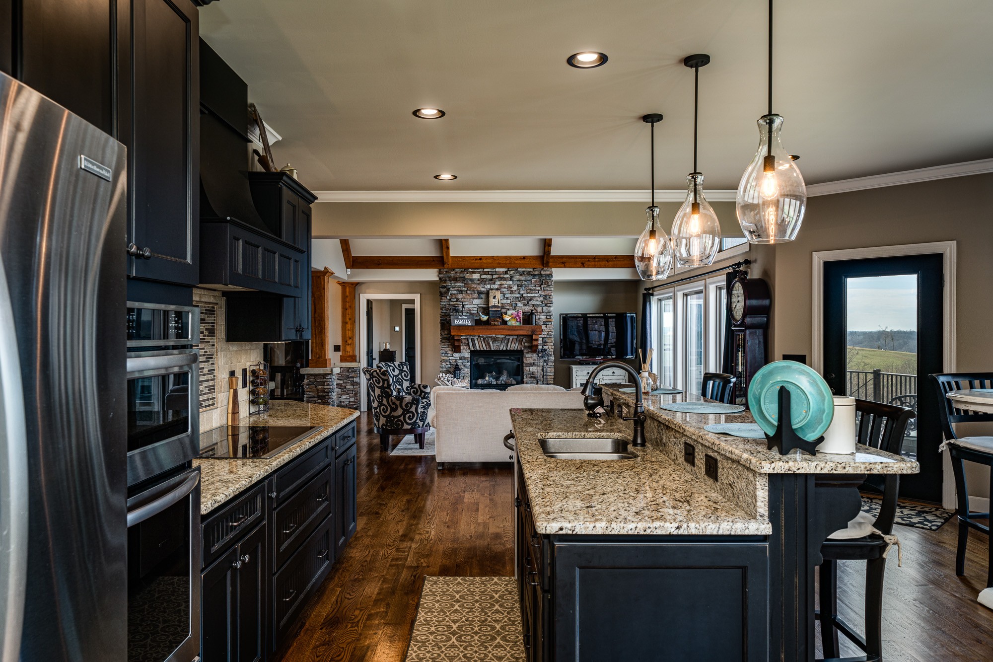 3639 Swan Ridge Road Celina, TN 38551 - Photo 9 of 37 a large kitchen with granite countertop a stove refrigerator a sink a dining table and chairs with wooden floor