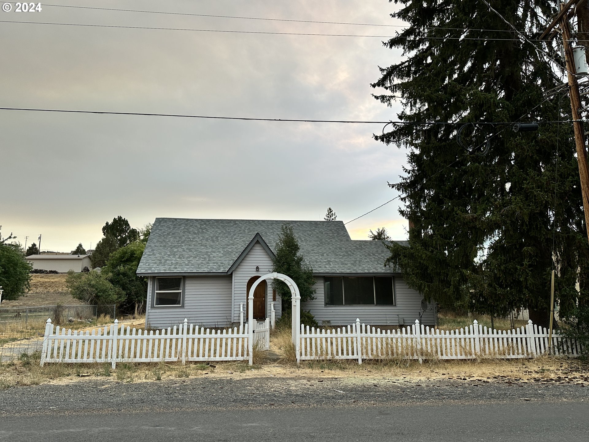 1175 Washington Street Fossil, OR 97830 - Photo 2 of 14 a front view of a house with a fence