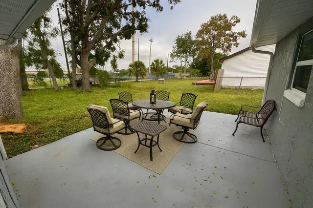 a view of a patio with table and chairs and garden