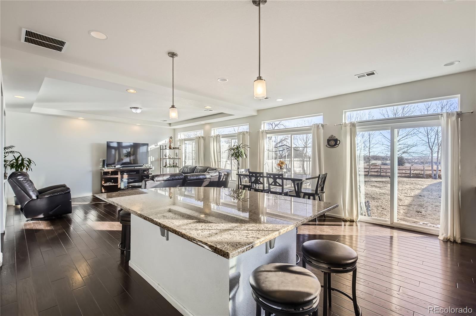 3423 Rosewood Lane Johnstown, CO 80534 - Photo 2 of 10 a living room with furniture a wooden floor and floor to ceiling window