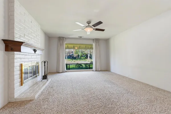 a livingroom with a ceiling fan and a window