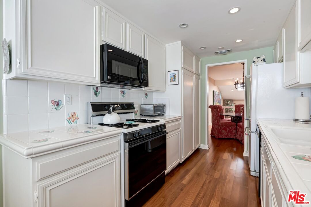 17171 Palisades Circle Pacific Palisades, CA 90272 - Photo 7 of 29 a kitchen with a sink stove and refrigerator