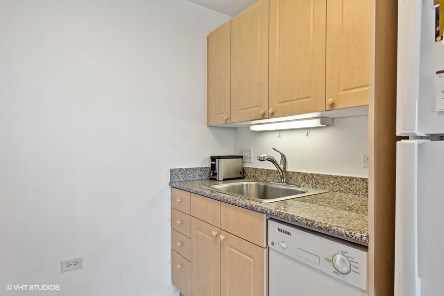 800 Elgin Road, Unit 604 Evanston, IL 60201 - Photo 9 of 17 a kitchen with granite countertop white cabinets and a sink