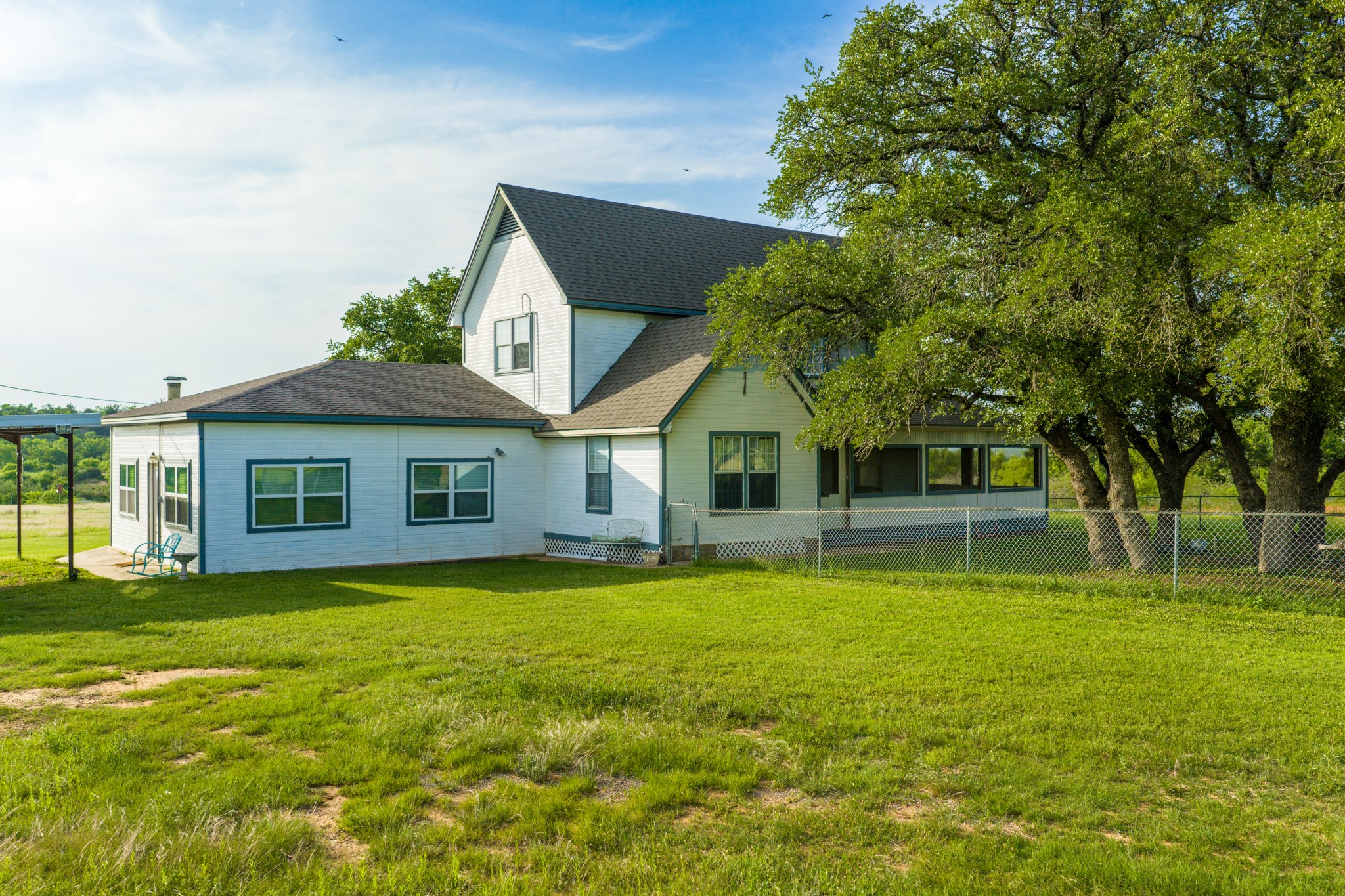 11079 Cr 266 Rochelle Tx 76872 Rochelle, TX 76872 - Photo 11 of 40 White exterior residence featuring a dark shingled roof and multiple windows with dark trim