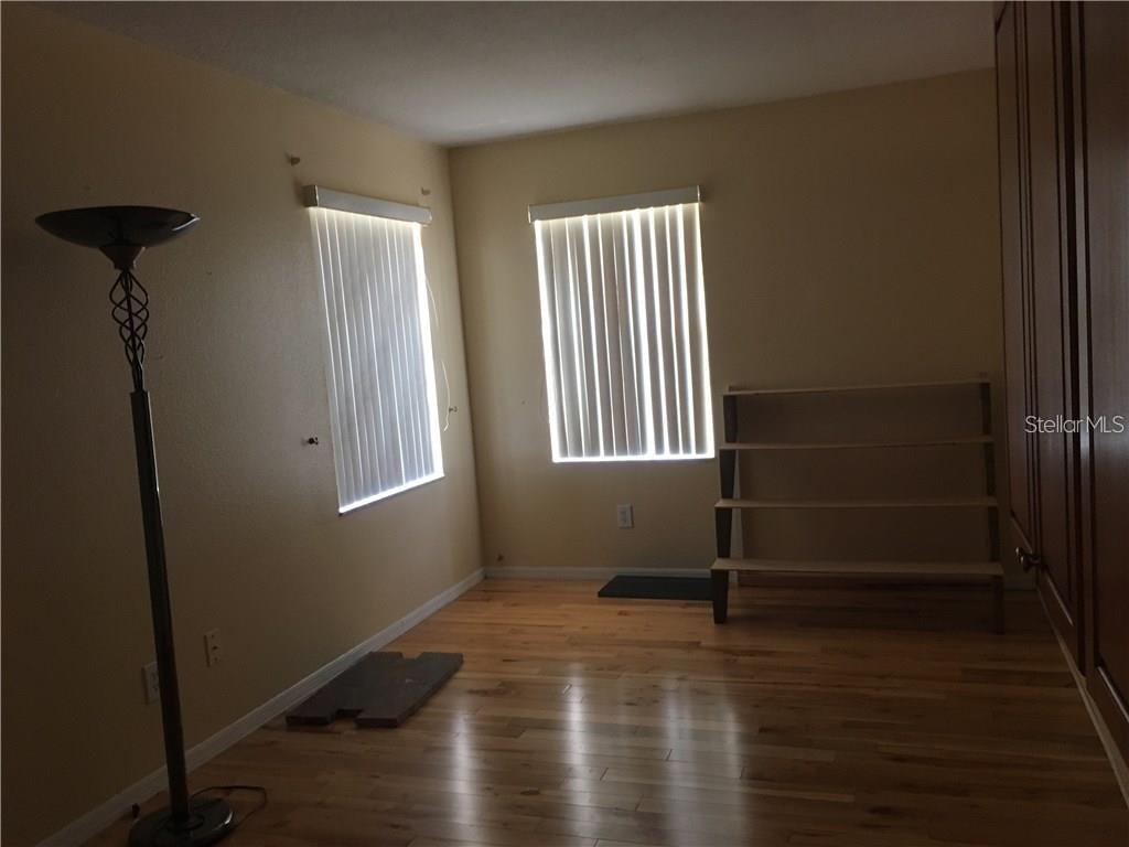 5948 Winchester Isle Road Orlando, FL 32829 - Photo 16 of 23 a view of empty room with wooden floor and fan
