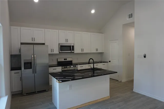 a kitchen with granite countertop a sink and steel stainless steel appliances