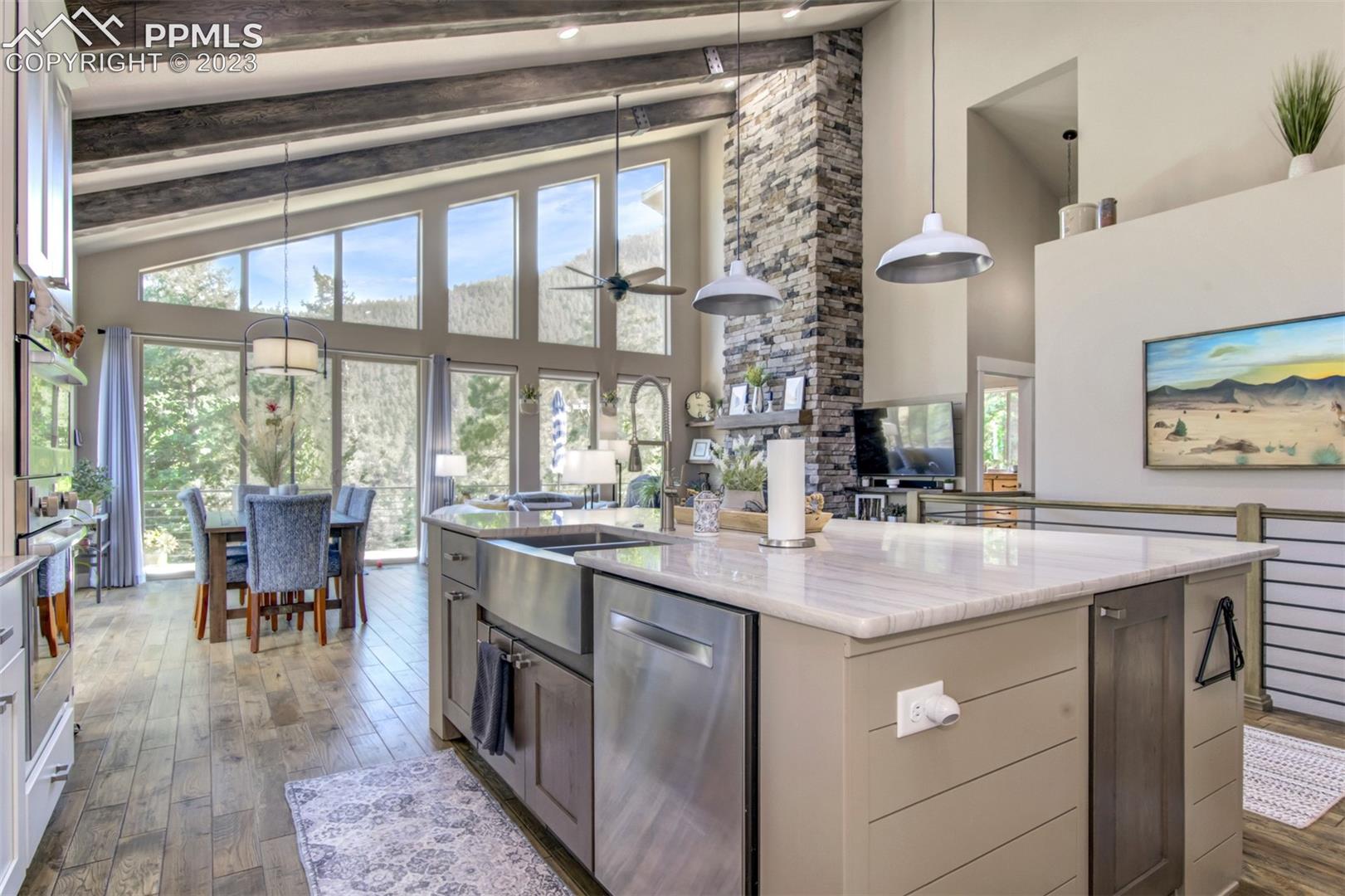 5020 South High Ridge View Manitou Springs, CO 80829 - Photo 11 of 46 Open concept kitchen looking into the dining and living room! Notice the large beamed ceilings and windows with views that go on forever!