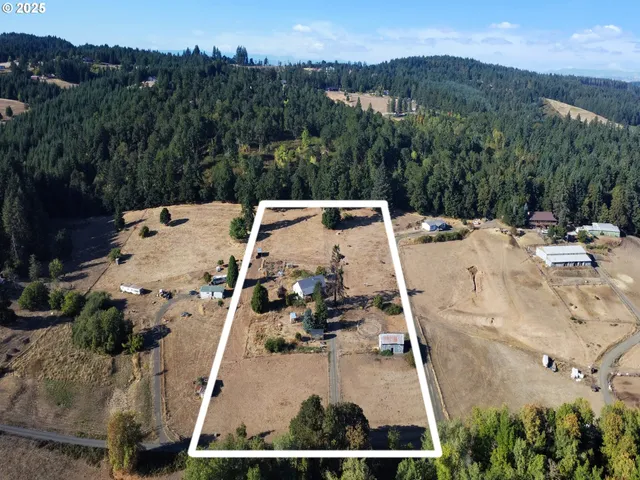 an aerial view of a house with a yard and mountain view