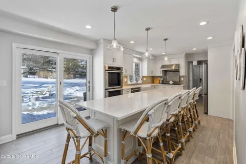 a view of a dining room and livingroom with furniture wooden floor a chandelier
