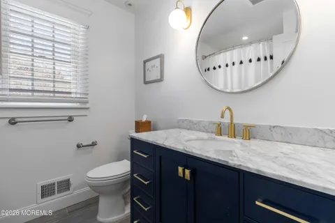 a bathroom with a granite countertop sink a toilet and a mirror