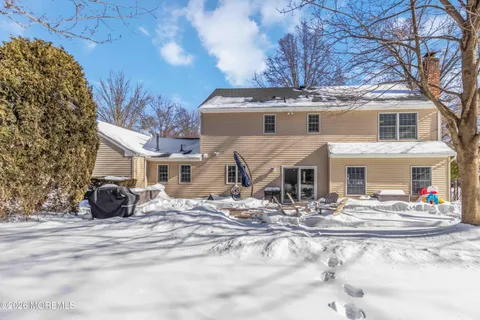 a view of a house with snow on the side of the road