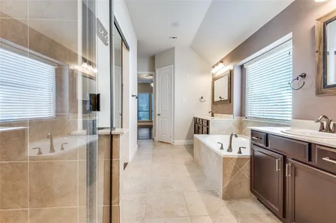 a spacious bathroom with a tub sink and mirror