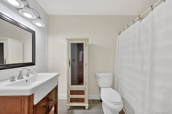 a bathroom with a toilet a sink and a mirror