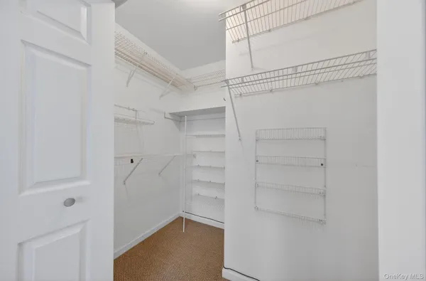 a view of walk in closet with empty racks