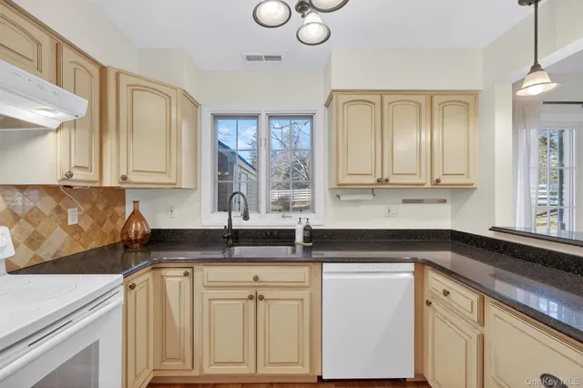 a kitchen with granite countertop a sink white cabinets and a granite counter tops