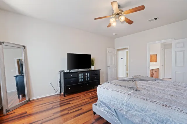 a bedroom with a bed and a flat tv screen on dresser