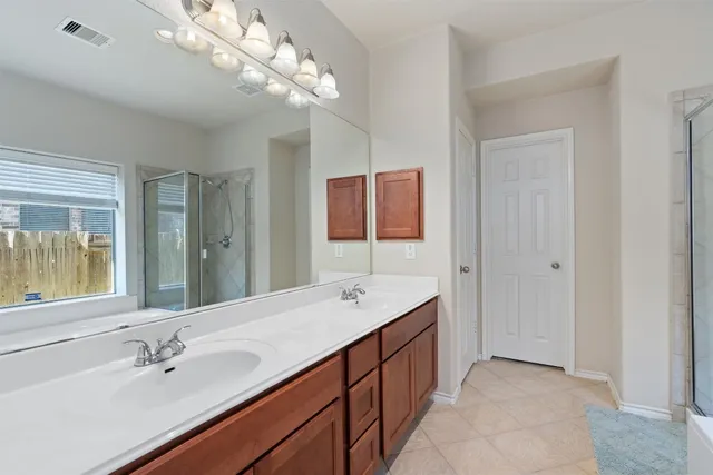 a spacious bathroom with a double vanity sink and a mirror