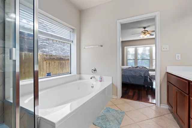 a en suite spacious bathroom with a tub shower and bedroom