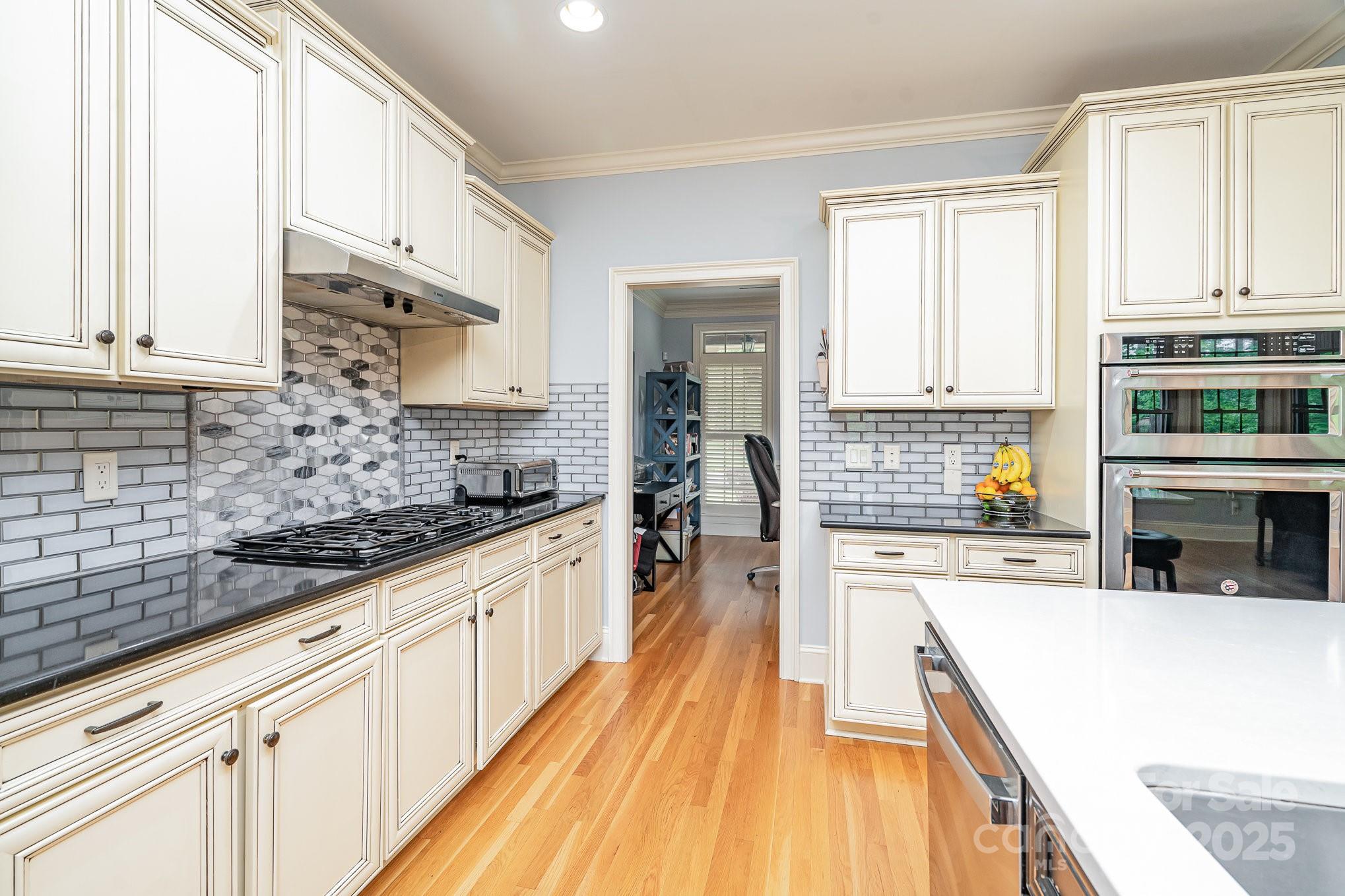 112 Spring Branch Road Fort Mill, SC 29715 - Photo 34 of 43 a kitchen with stainless steel appliances granite countertop a stove a sink and white cabinets with wooden floor