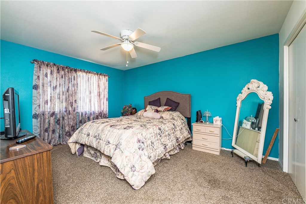 28241 Winged Foot Drive Menifee, CA 92586 - Photo 17 of 25 a bedroom with a bed and a chandelier