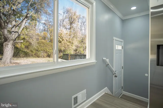 a view of small space with wooden floor and fan