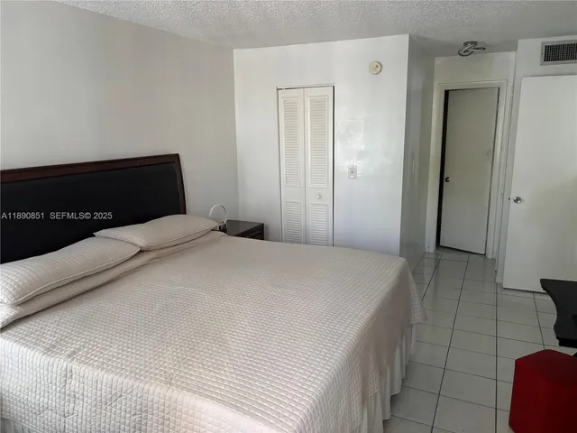 a bedroom with a bed and a potted plant on table
