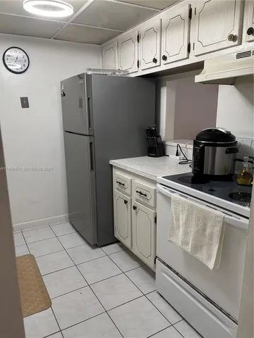 a kitchen with stainless steel appliances granite countertop a refrigerator a stove and a sink