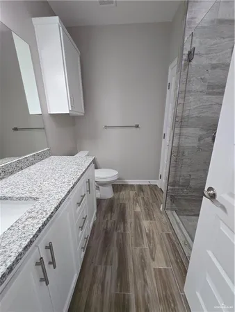 a bathroom with a granite countertop sink toilet and shower