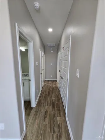 a view of a hallway with wooden floor and staircase