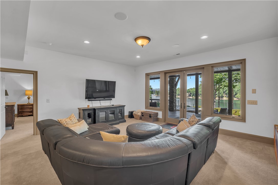 256 Talton Road Six Mile, SC 29682 - Photo 34 of 50 Glass doors frame serene water views from this comfortable carpeted living space.