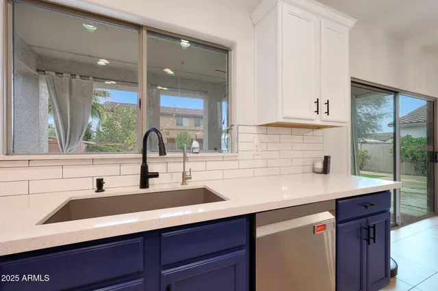 a large kitchen with stainless steel appliances a sink and cabinets