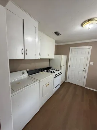 a view of washer and dryer with wooden cabinet