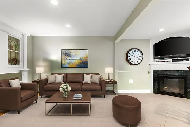 a living room with furniture a clock and a fireplace